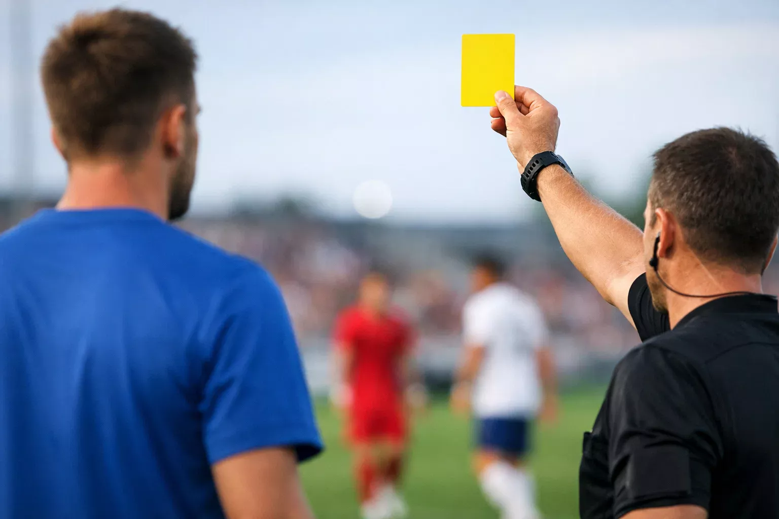 Speler ontvangt gele kaart van scheidsrechter op grasveld